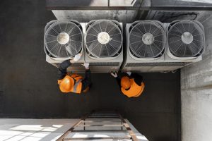 Gli impianti di refrigerazione green si basano su tecnologie ecosostenibili capaci di ridurre consumi e sprechi energetici. Nella foto alcuni operai che montano un impianto di refrigerazione.