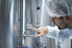 Sono tanti gli sbocchi offerti dalla fluidotecnica industriale: questi vanno da quelli classici a quelli più specialistici. Nella foto, un operaio che controlla la pressione dei fluidi in una tubazione.