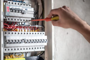 Corrente elettrica e trasferimento di potenza sono due elementi del fenomeno elettrico che costituiscono la base per scienze quali l'ingegneria elettrica ed elettronica. Nella foto, un tecnico al lavoro su un circuito elettrico.